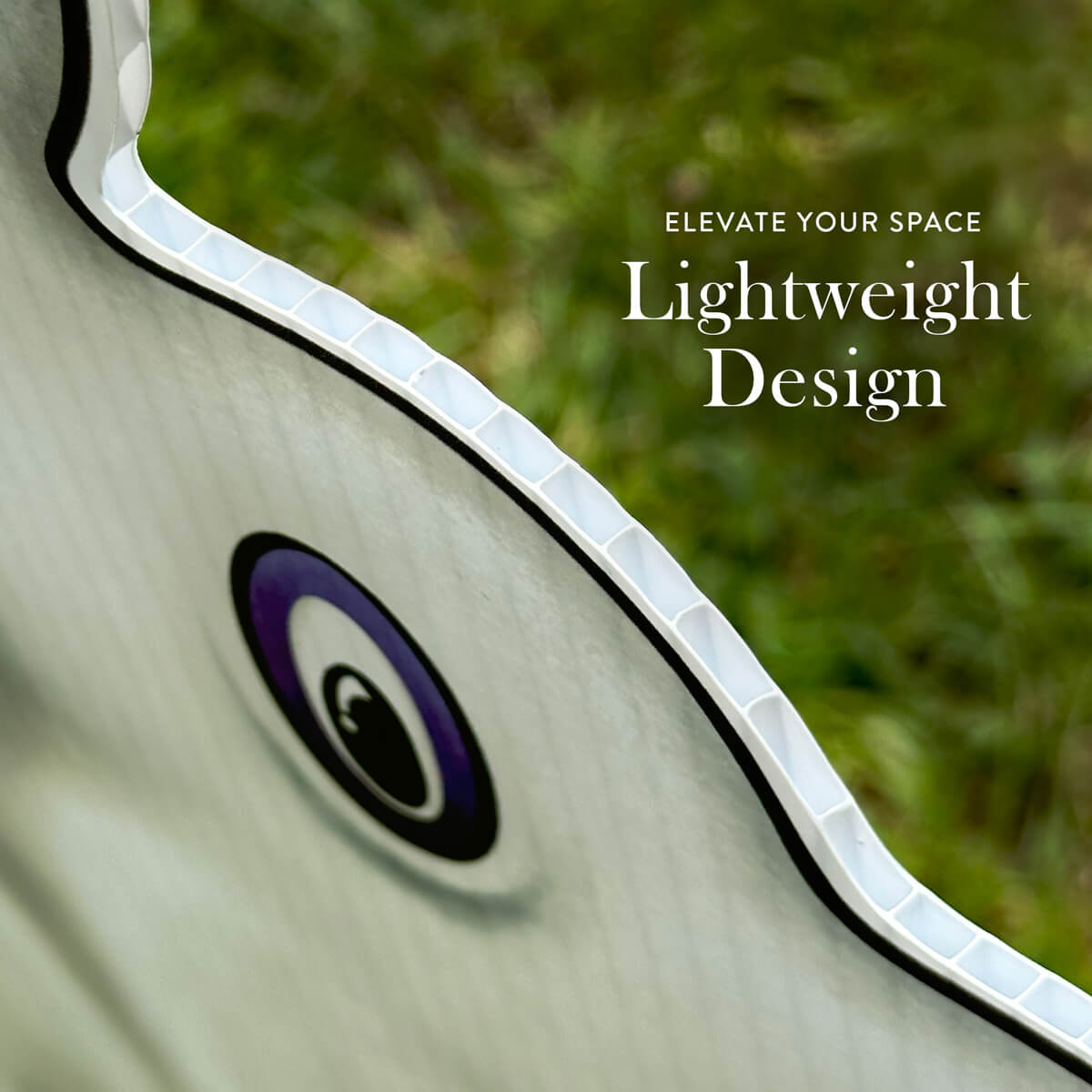 Close-up of a decorative Ghost Bead Dog corrugated sign with text 'Elevate Your Space Lightweight Design' on a blurred green background