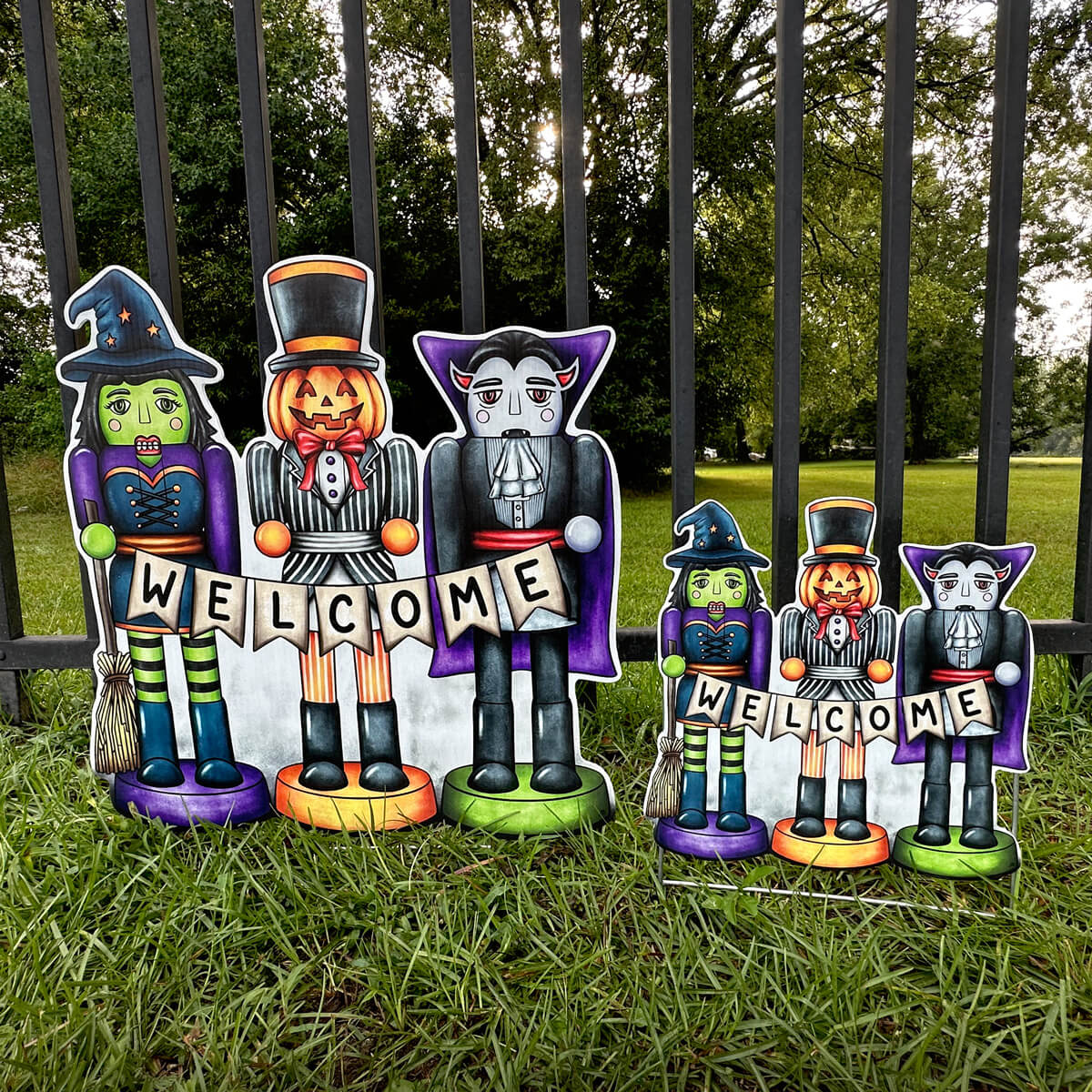 Halloween-themed Nutcracker decorative figures with 'WELCOME' signs on grass