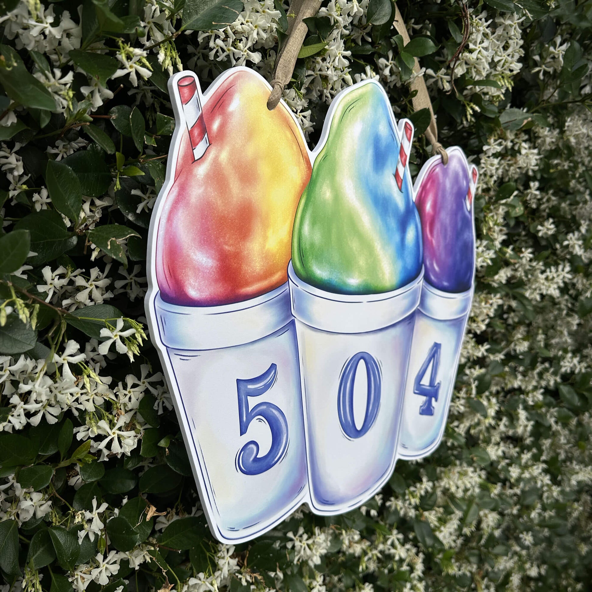 Side view of rainbow snoballs door hanger on jasmine plant background