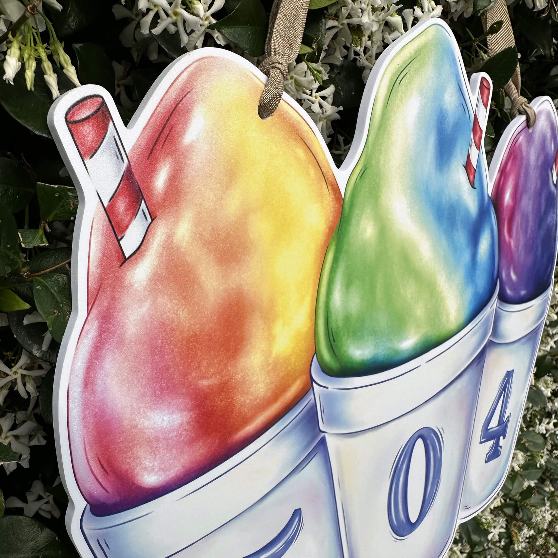 Colorful snoball door hanger with a straw and number '504' against a natural background