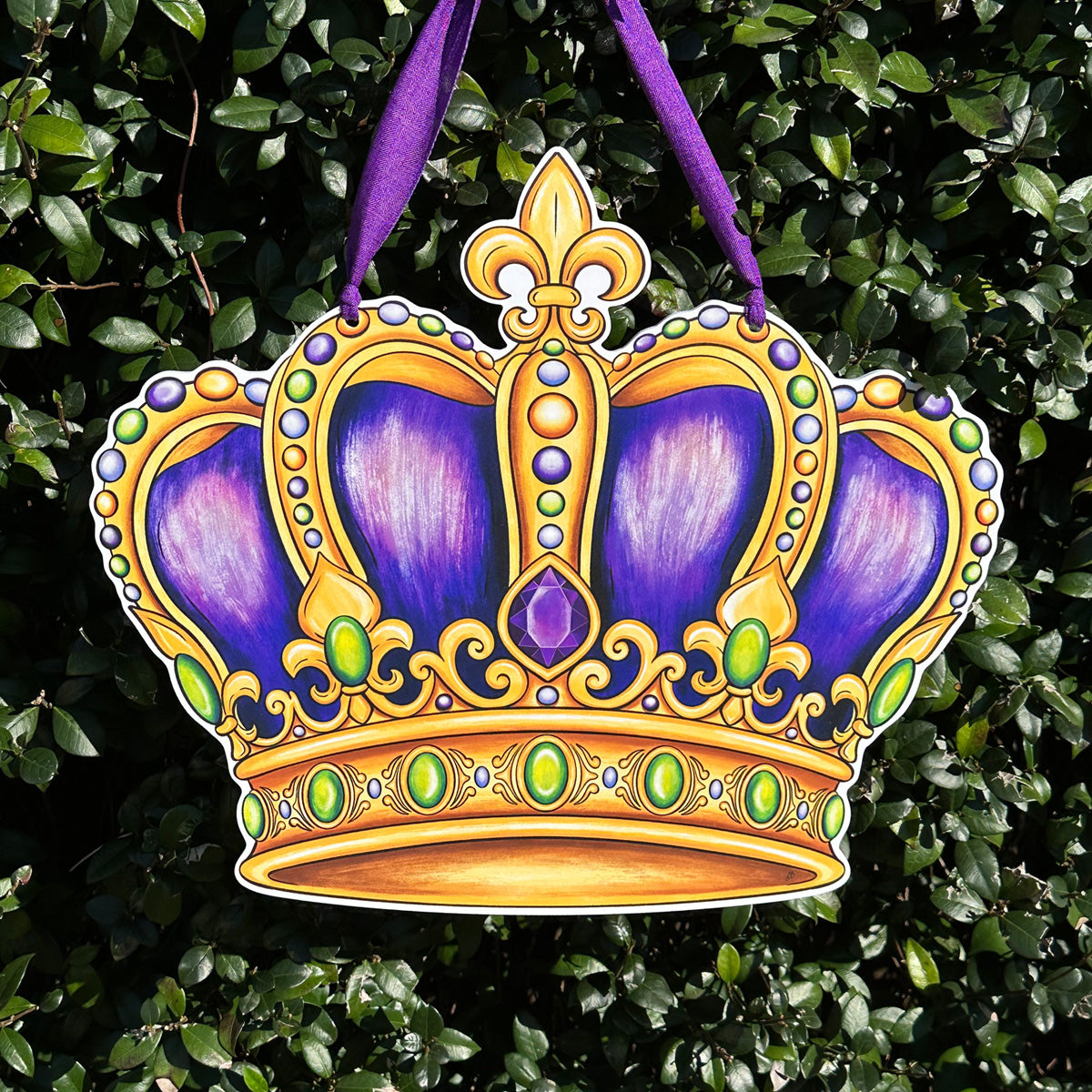 Mardi Gras Crown Door Hanger with jewels in purple, green, and gold on a leafy background.